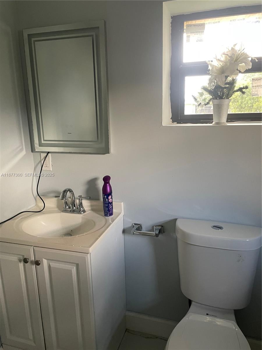 2785 Northwest 59th Street, Unit 2 Miami, FL 33142 - Photo 2 of 5 a bathroom with a toilet sink and mirror