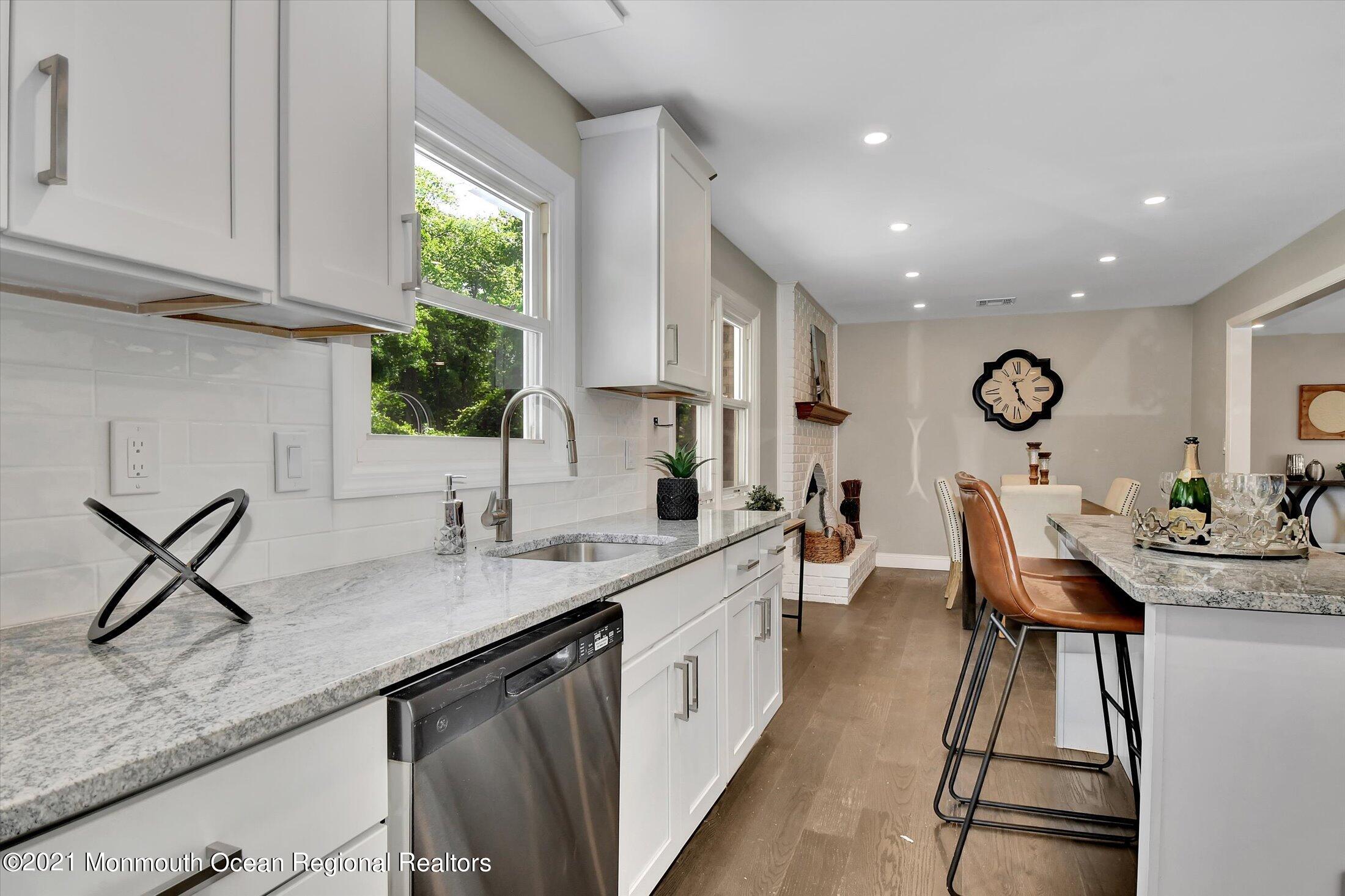 347 Iron Ore Road Manalapan, NJ 07726 - Photo 14 of 27 a open kitchen with stainless steel appliances granite countertop a sink dishwasher a microwave oven with white cabinets and wooden floor