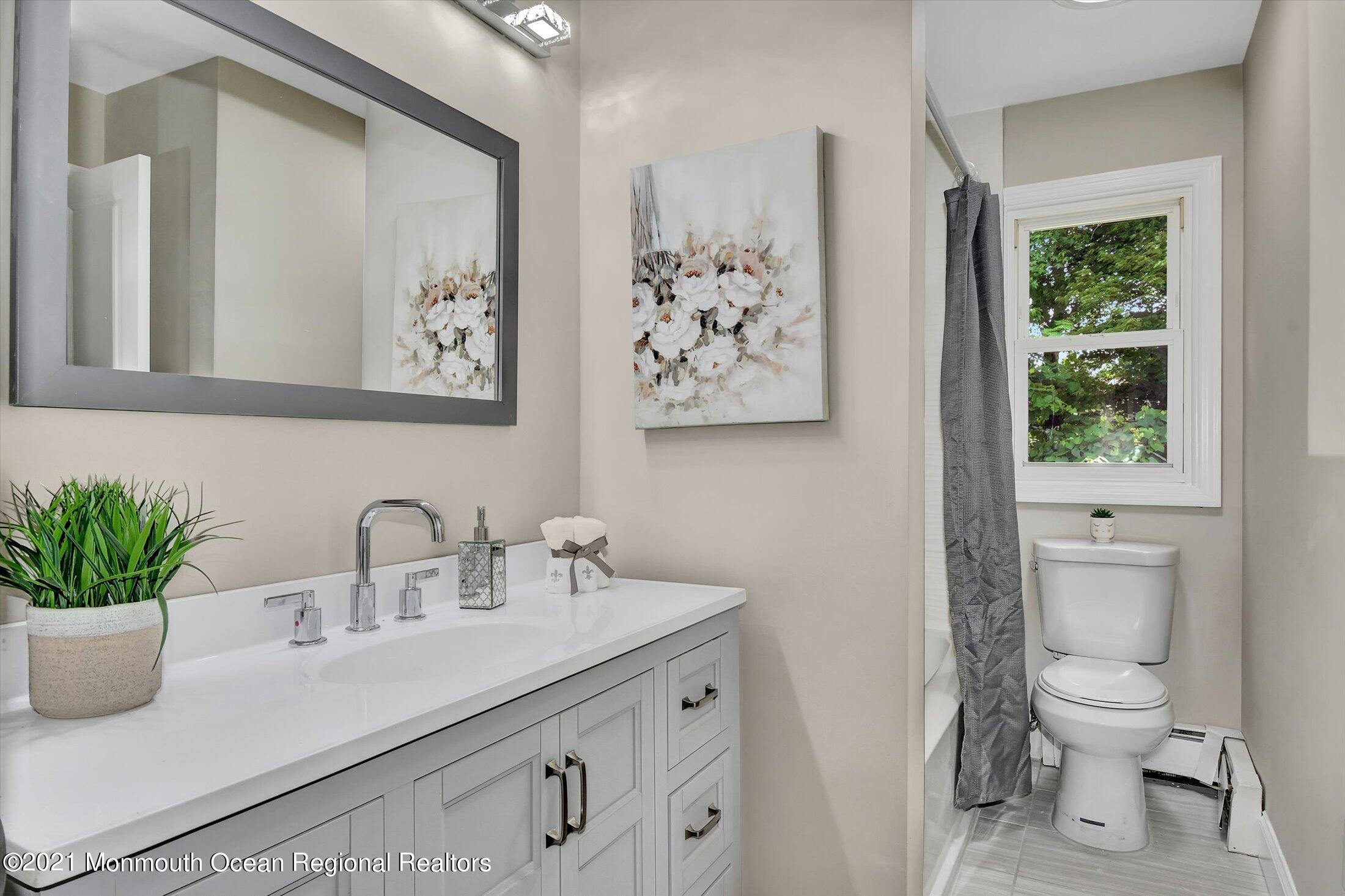 347 Iron Ore Road Manalapan, NJ 07726 - Photo 19 of 27 a bathroom with a toilet sink and mirror