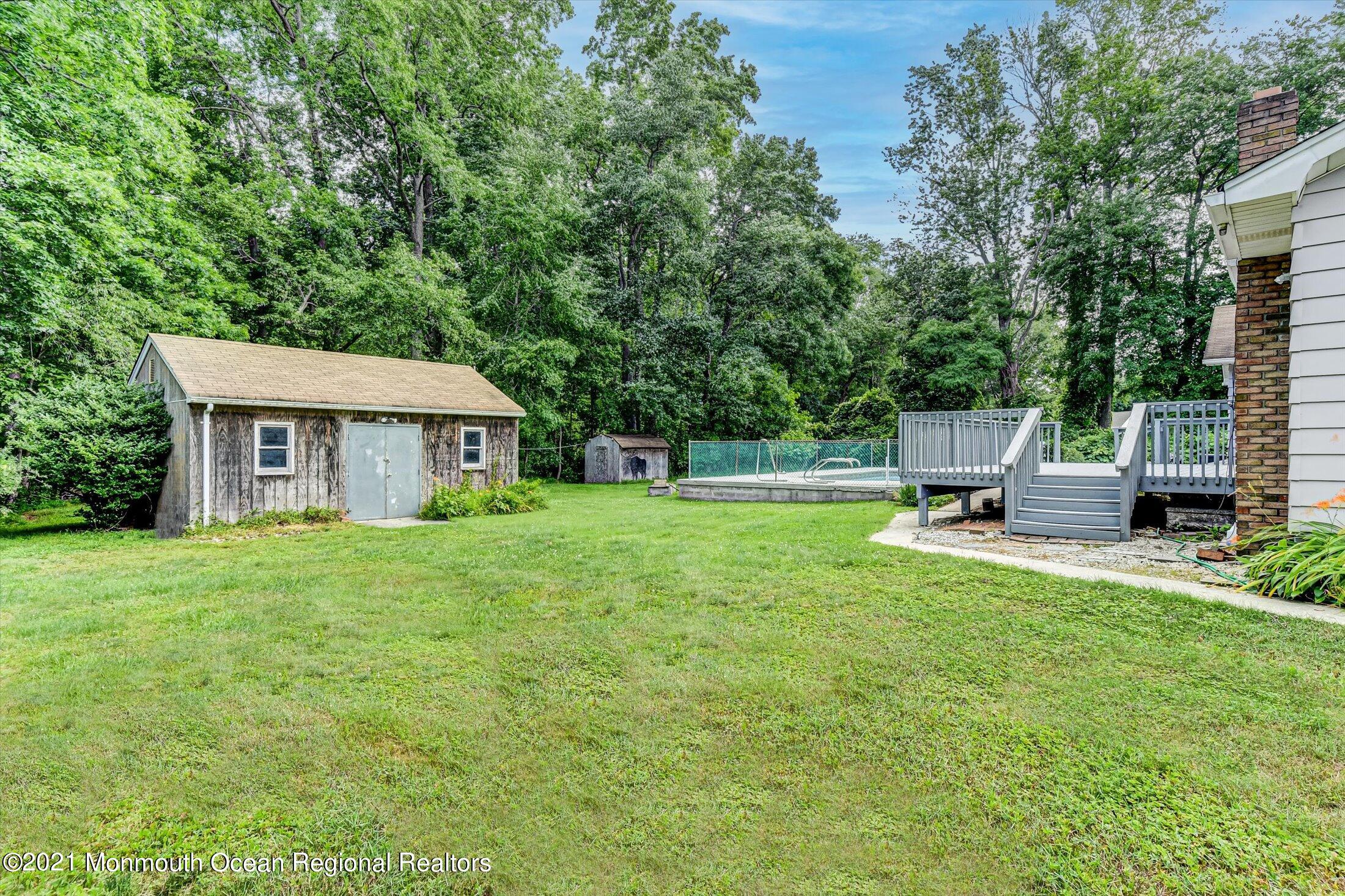 347 Iron Ore Road Manalapan, NJ 07726 - Photo 25 of 27 a front view of a house with a garden and trees