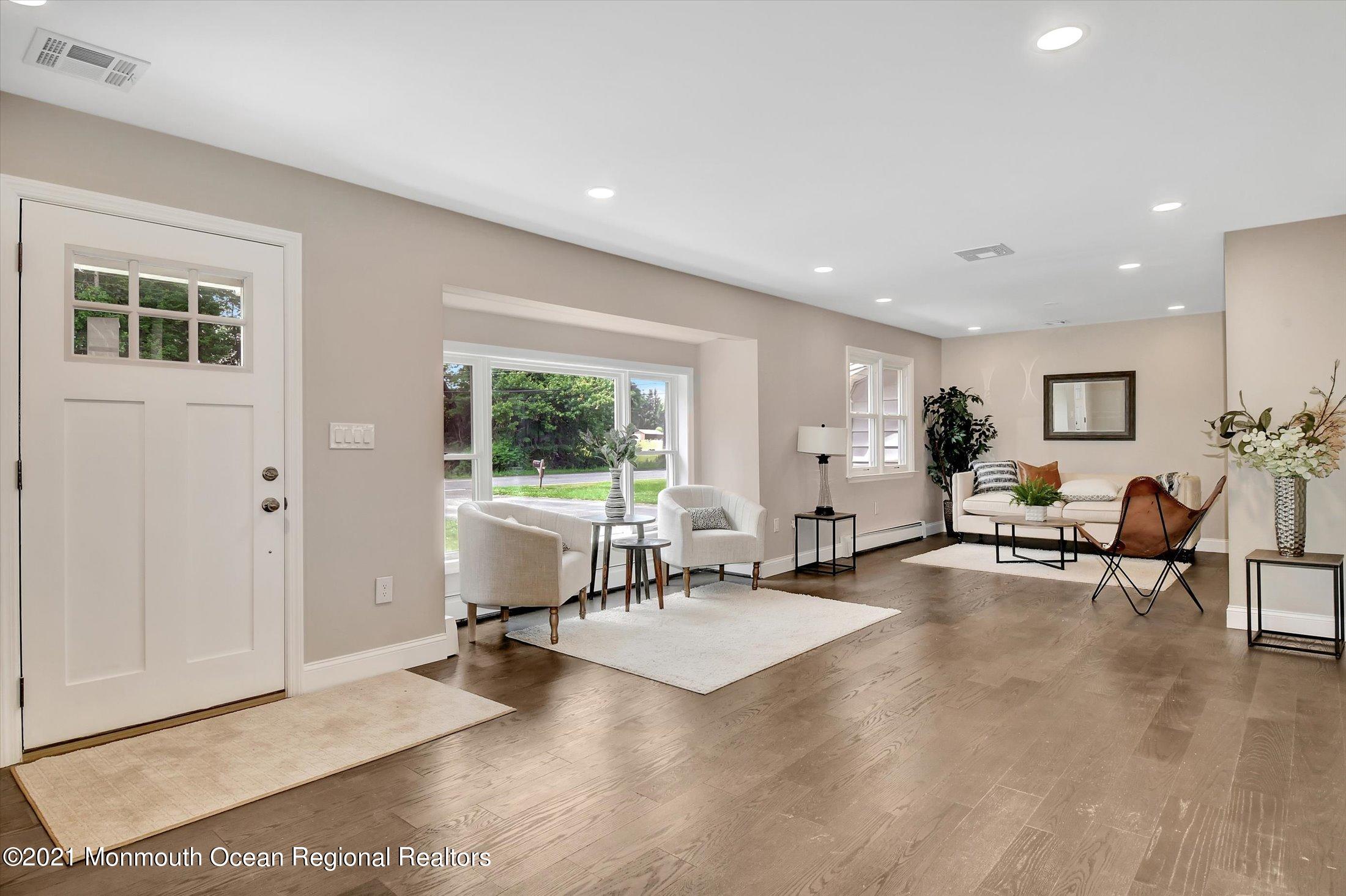 347 Iron Ore Road Manalapan, NJ 07726 - Photo 4 of 27 a living room with furniture a window and gym equipment