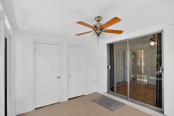 a view of a hallway with a chandelier fan and closet area