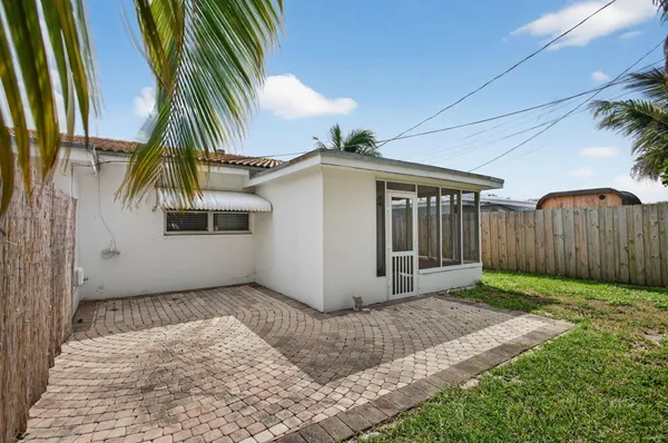 a view of a white house with a yard and potted plants