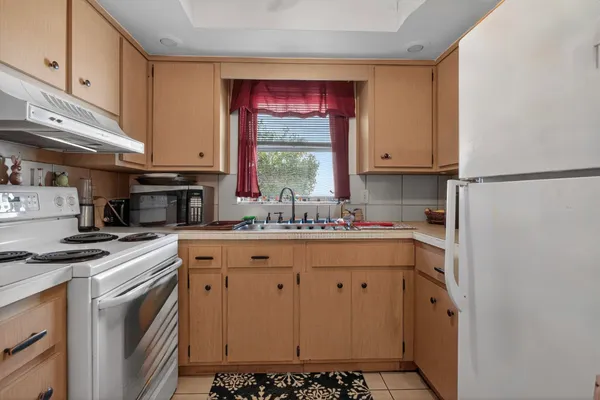 a kitchen with stainless steel appliances a stove a sink and a refrigerator