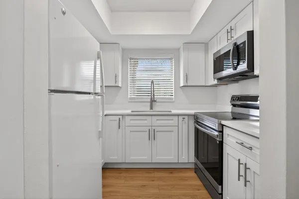 a kitchen with stainless steel appliances granite countertop a stove a sink and a refrigerator