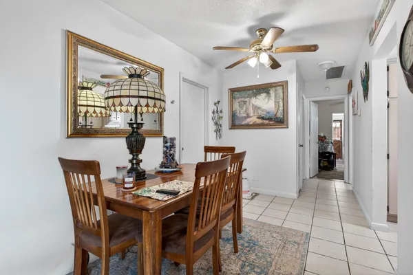 a view of a dining room with furniture and a chandelier fan