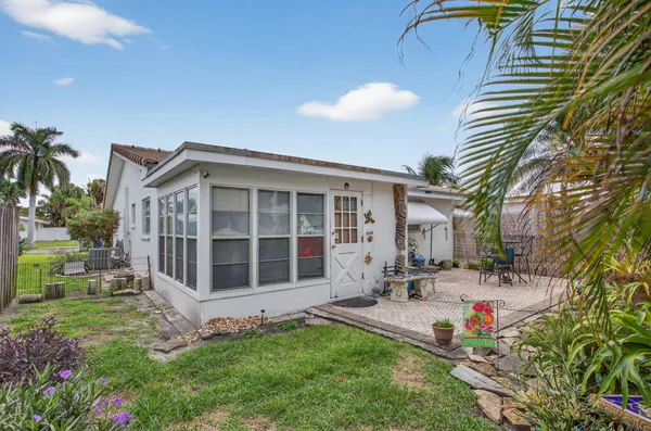 a view of a house with backyard sitting area and garden