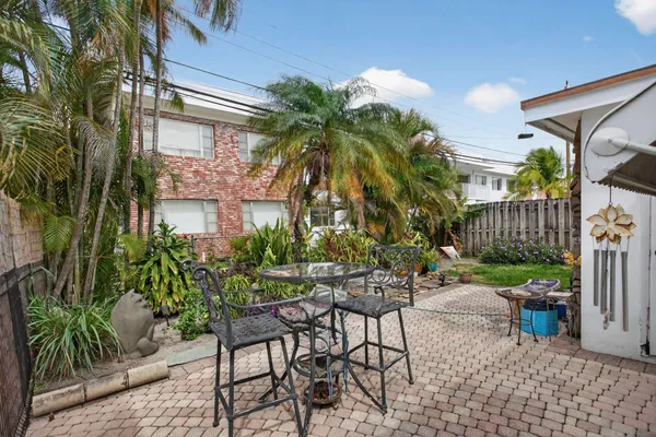a view of a chair and table in backyard of the house