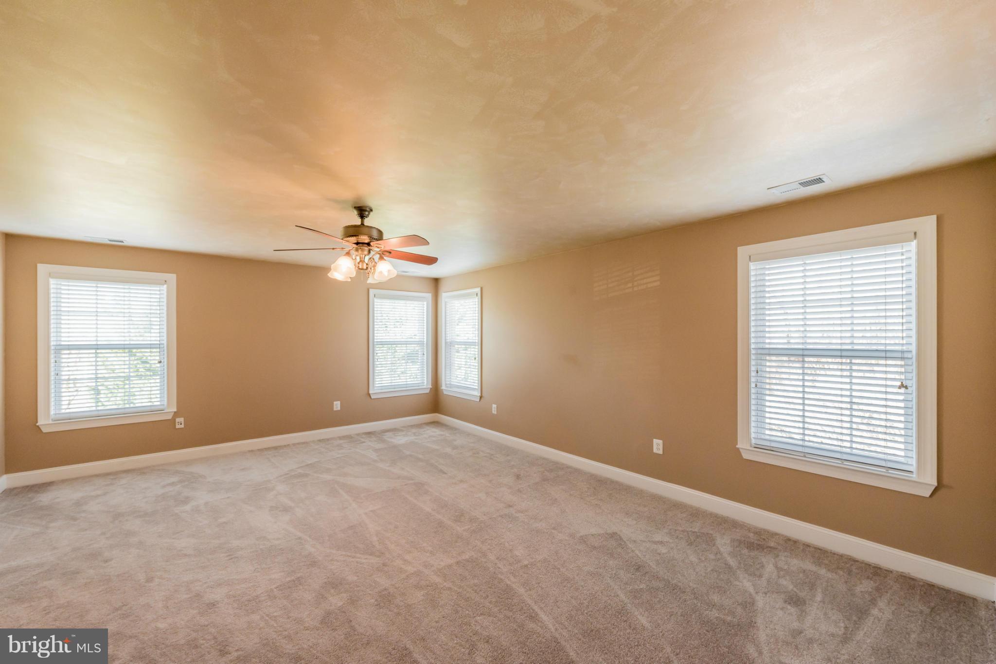 3401 Evans Road Huntingtown, MD 20639 - Photo 12 of 30 an empty room with windows and fan