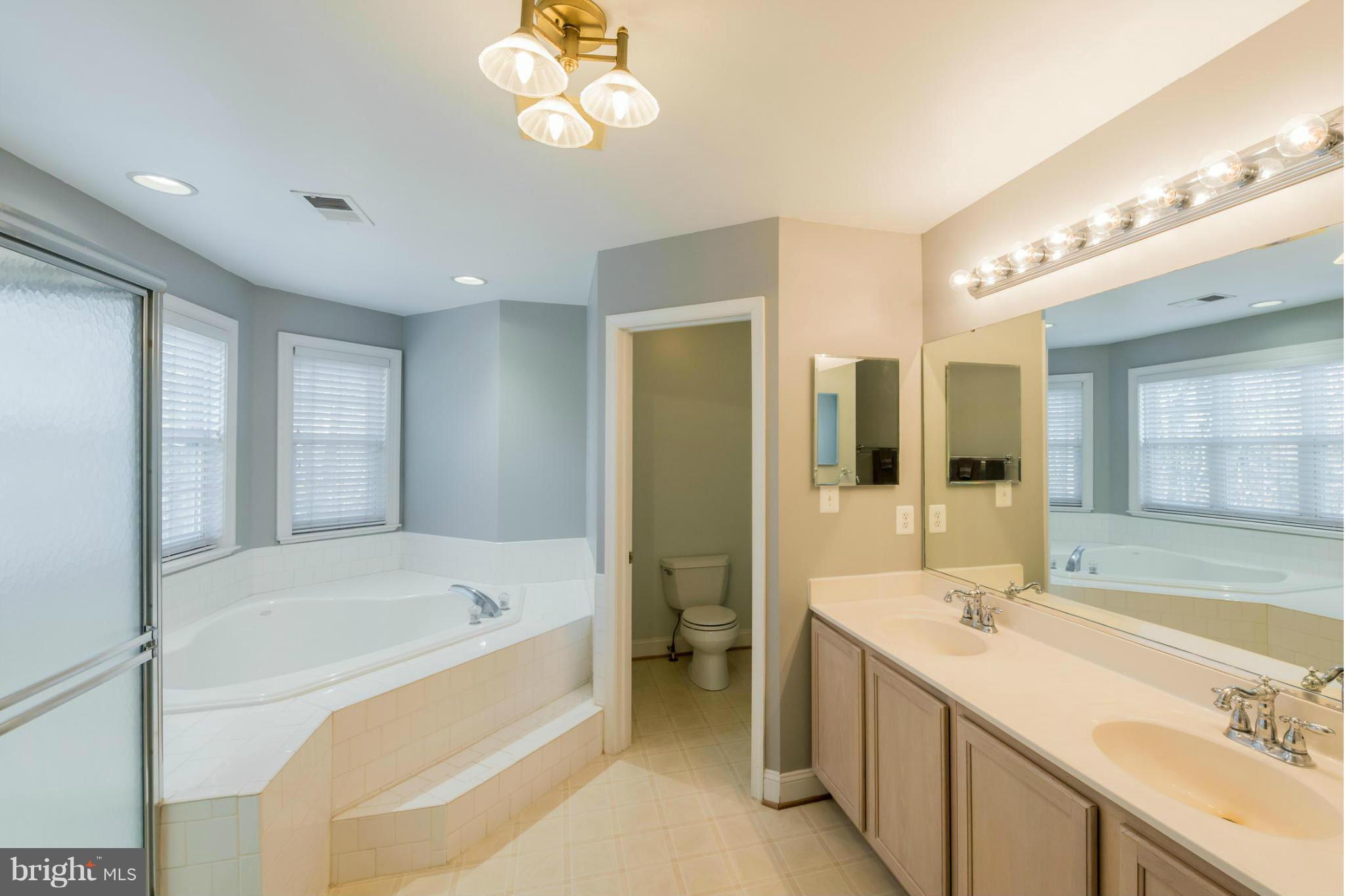 3401 Evans Road Huntingtown, MD 20639 - Photo 13 of 30 a bathroom with a bathtub a sink and a large mirror