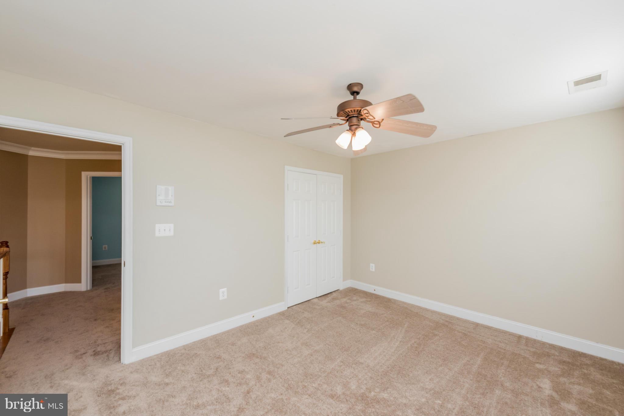 3401 Evans Road Huntingtown, MD 20639 - Photo 17 of 30 an empty room with a chandelier fan and view of bathroom