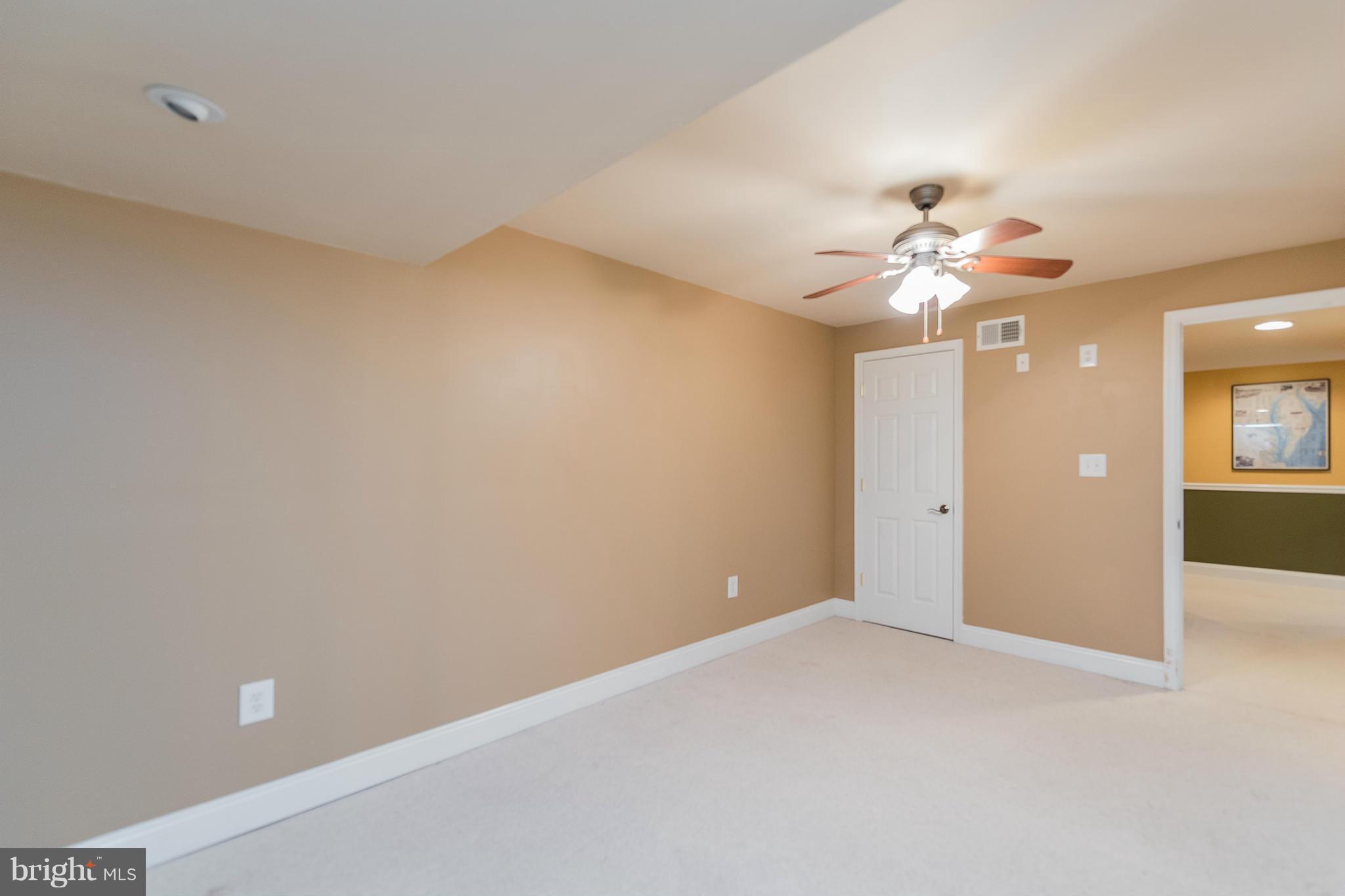 3401 Evans Road Huntingtown, MD 20639 - Photo 19 of 30 wooden floor in an empty room with a chandelier fan