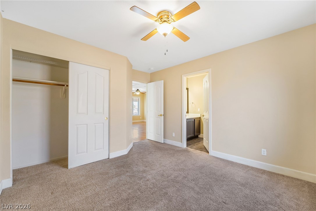 271 Pointe Ranier Avenue Henderson, NV 89012 - Photo 15 of 26 This cozy bedroom features plush carpet and an adjoining private bathroom for comfort and convenience.