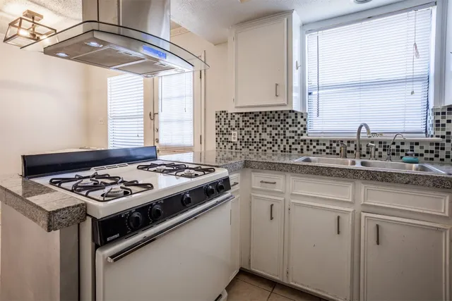 a white stove top oven sitting inside of a kitchen