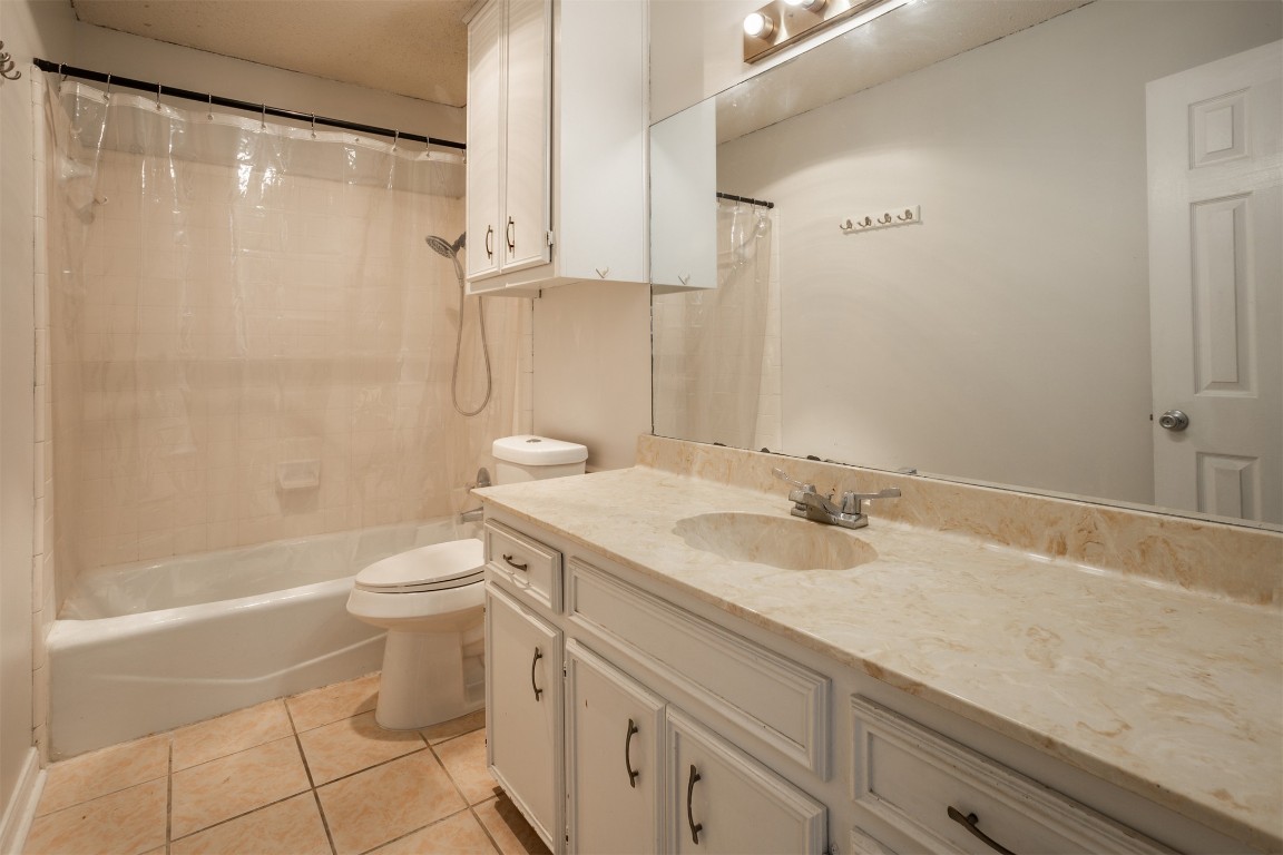 7800 Northcrest Boulevard, Unit 203 Austin, TX 78752 - Photo 17 of 19 a bathroom with a granite countertop sink a toilet a mirror and shower