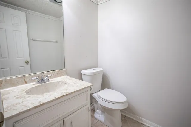 a bathroom with a granite countertop toilet and a sink
