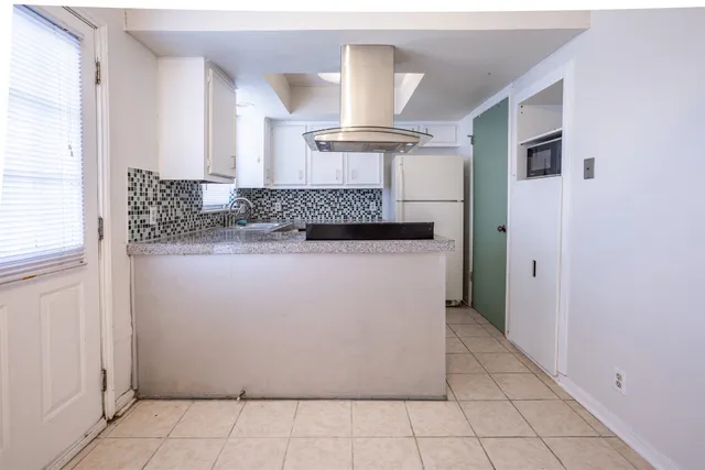 a view of a kitchen with white cabinets