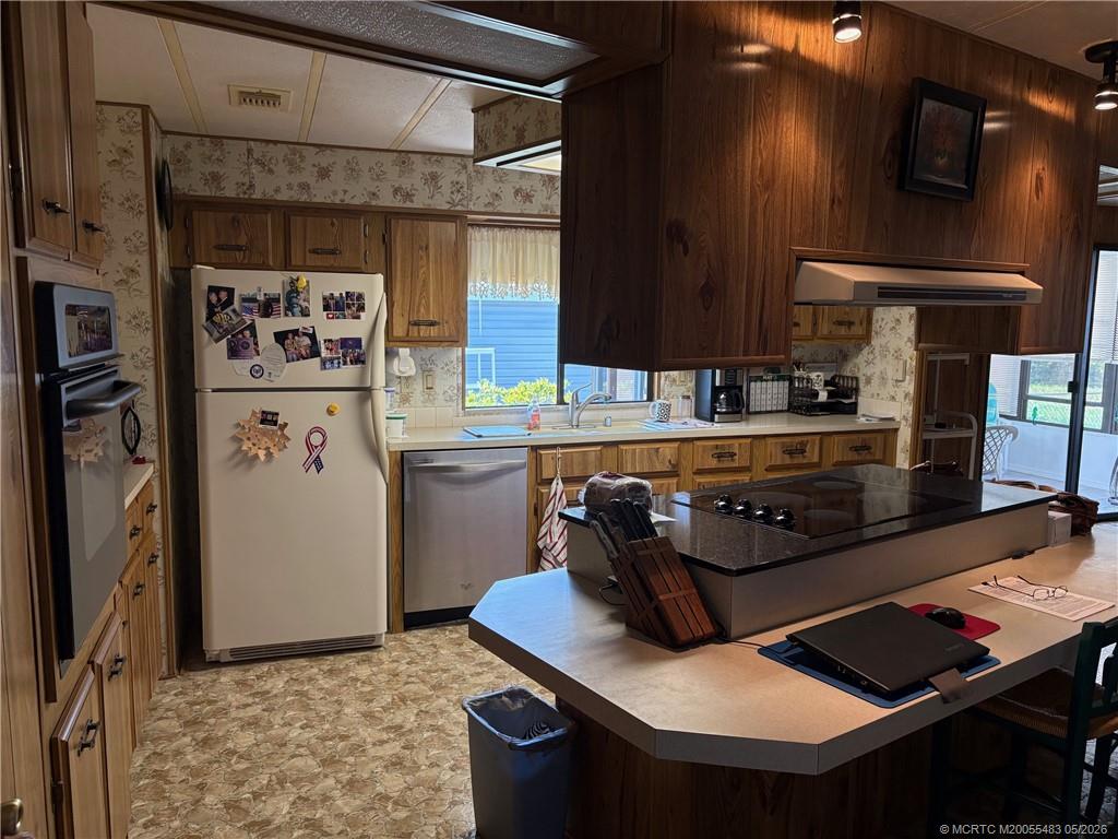 2856 Southwest Toronado Trail Stuart, FL 34997 - Photo 9 of 20 a kitchen with a stove and a refrigerator