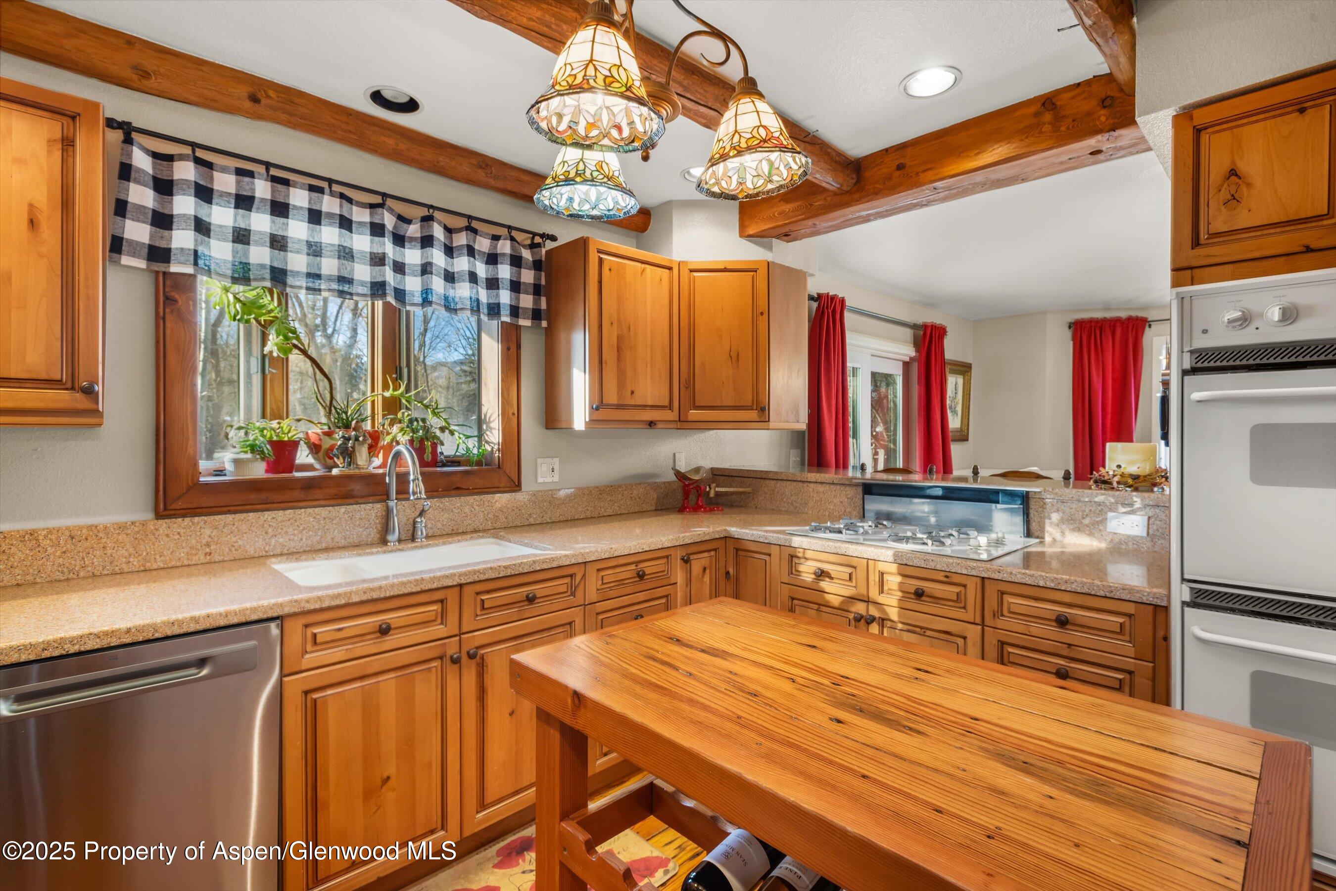 93 Quail Run Carbondale, CO 81623 - Photo 13 of 36 a kitchen with stainless steel appliances wooden cabinets a sink and a stove