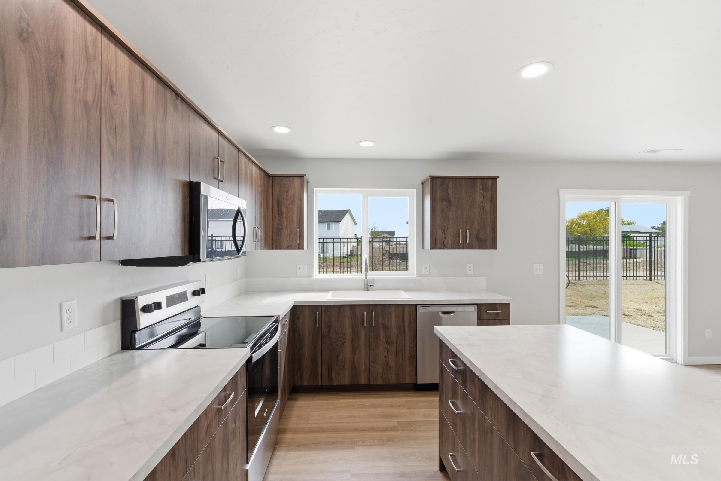 16558 Dunning Way Caldwell, ID 83607 - Photo 4 of 35 Modern kitchen featuring wood-finish cabinetry, light-toned countertops, and stainless steel appliances