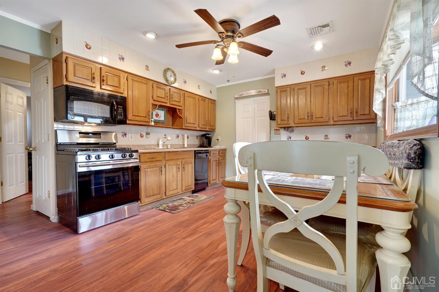 27 Raleigh Road Edison, NJ 08817 - Photo 7 of 29 a kitchen with a stove a refrigerator and a microwave