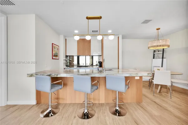 a kitchen with a table chairs and wooden floor