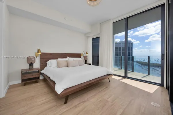 a spacious bedroom with a bed and a large window
