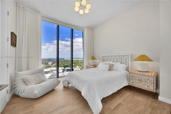 a bedroom with a bed and a large window