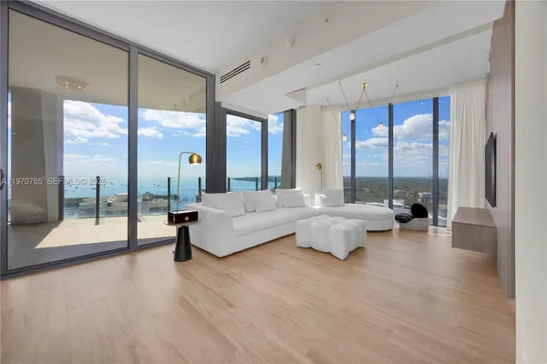 a living room with couches and a large window with outer view