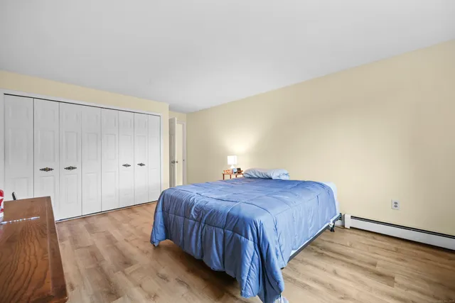 a bedroom with a bed and wooden floor
