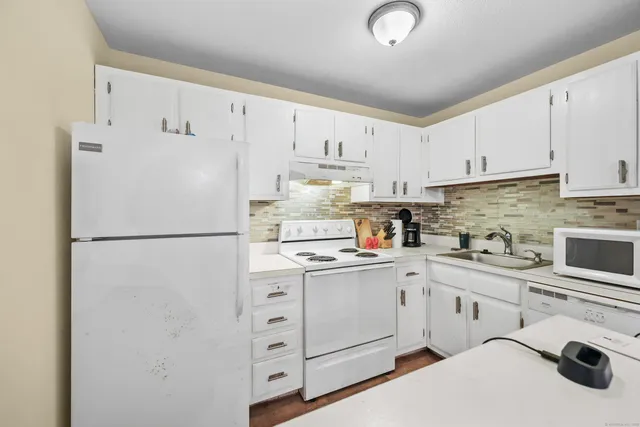 a white refrigerator freezer sitting in a kitchen