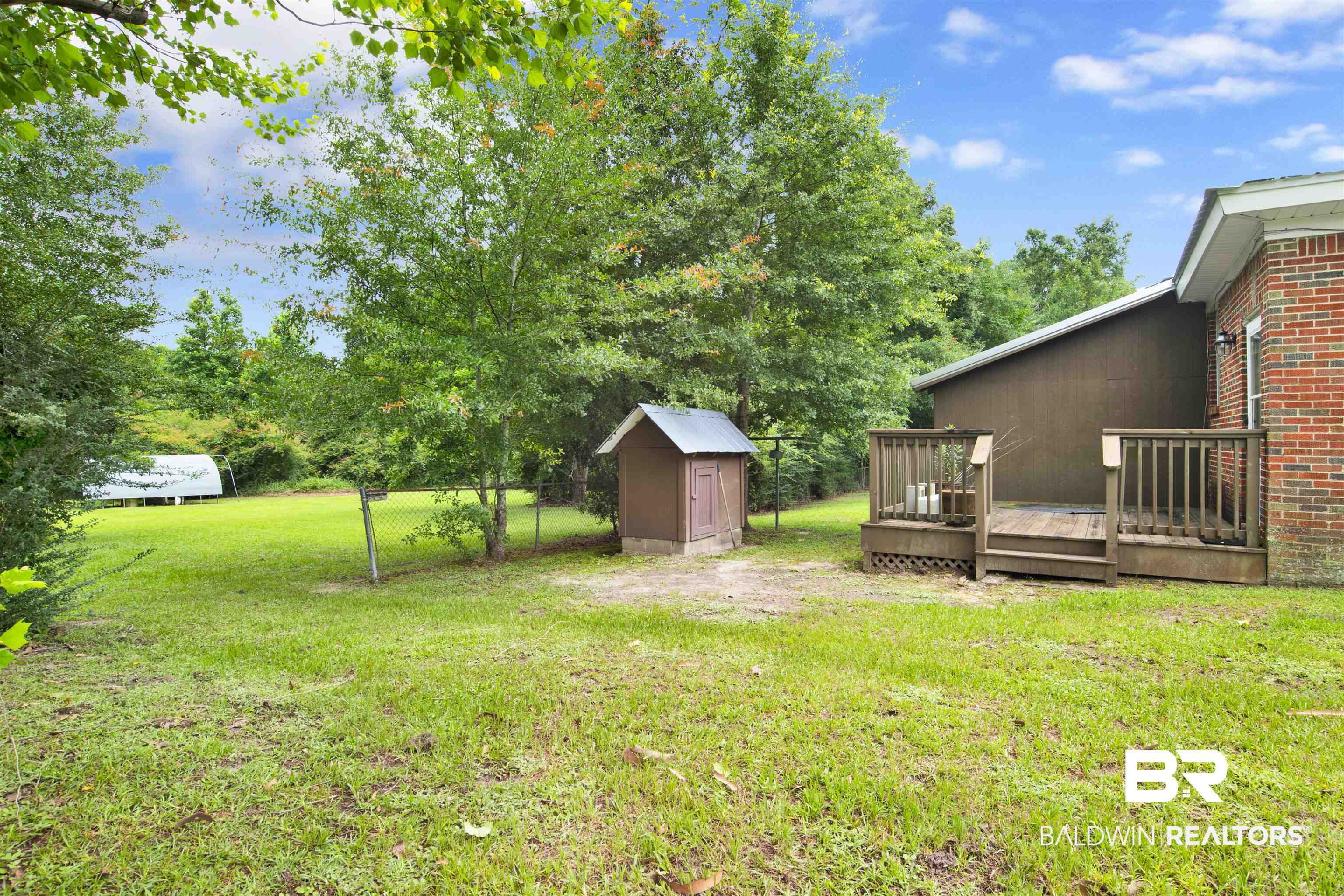 17714 Horseneck Road Bay Minette, AL 36507 - Photo 34 of 36 Expansive backyard featuring a wood deck, a brick exterior, and mature trees