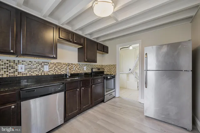 a kitchen with stainless steel appliances granite countertop a refrigerator and a sink