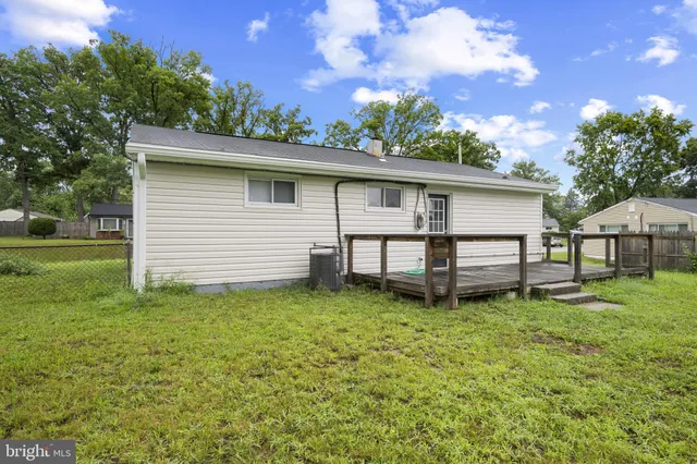 a white house that has a small yard and a large tree
