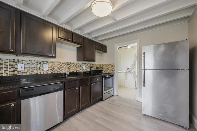 a kitchen with stainless steel appliances granite countertop a refrigerator and a sink