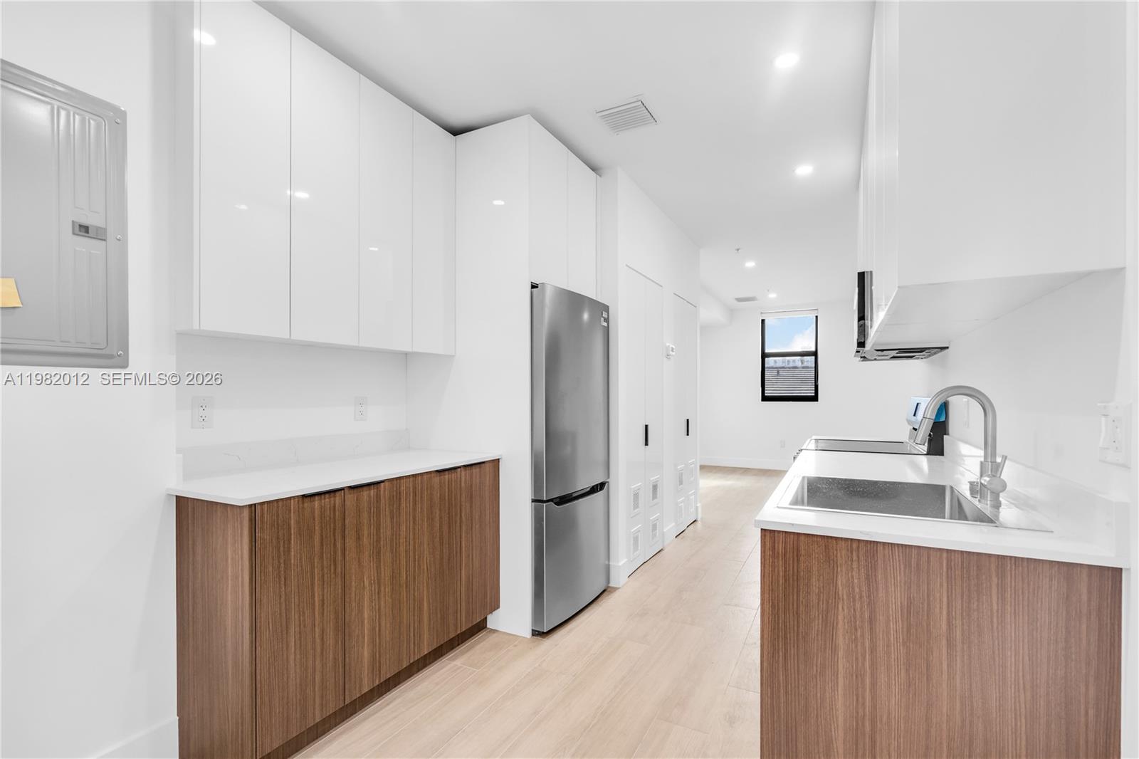 1037 Northwest 2nd Street, Unit 2B2 Miami, FL 33128 - Photo 2 of 15 a kitchen with stainless steel appliances a sink refrigerator and cabinets