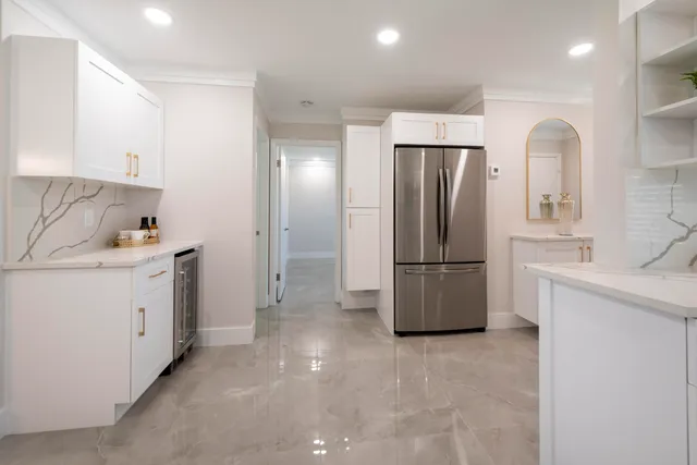 a kitchen with granite countertop white cabinets and white appliances