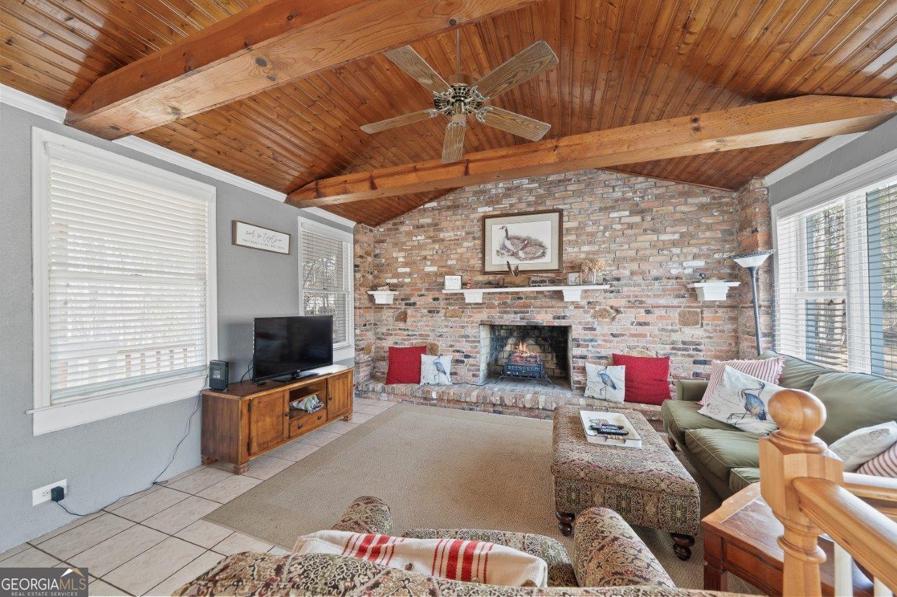 109 Horseshoe Bend Road Southwest Eatonton, GA 31024 - Photo 20 of 42 a living room with furniture a flat screen tv and a fireplace
