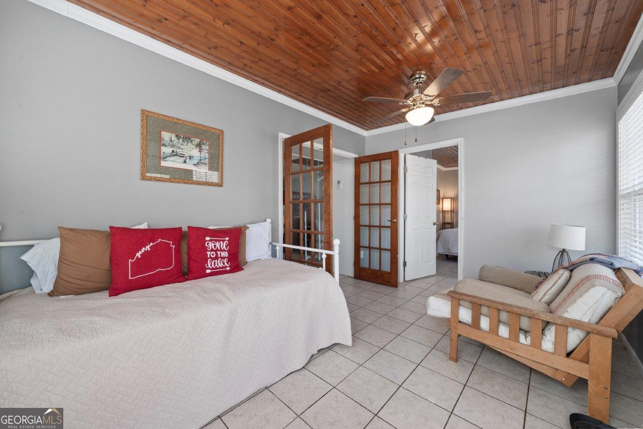 109 Horseshoe Bend Road Southwest Eatonton, GA 31024 - Photo 31 of 42 a bedroom with a large bed and a chandelier
