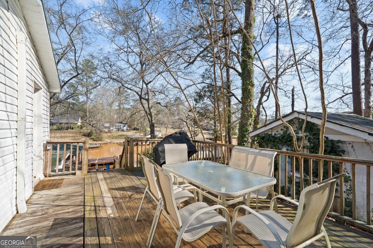 109 Horseshoe Bend Road Southwest Eatonton, GA 31024 - Photo 8 of 42 a view of a patio with table and chairs with wooden floor and fence