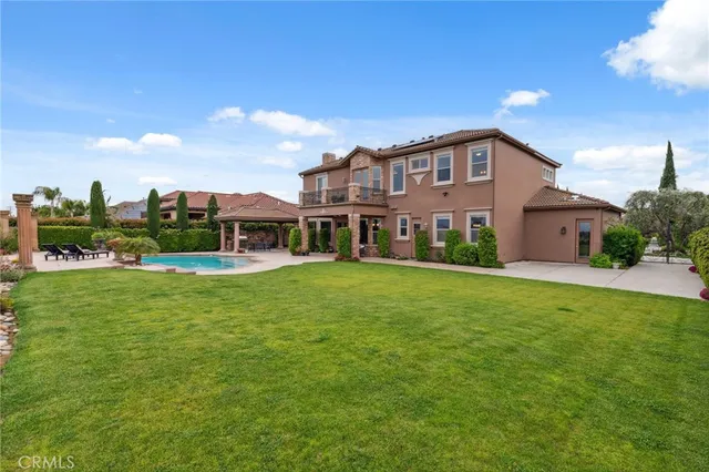 a view of a patio with table and chairs under an umbrella with a small yard