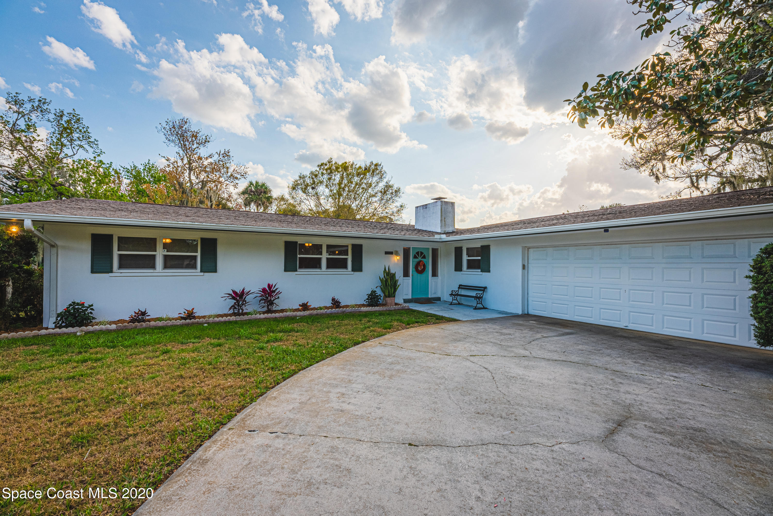 a front view of house with yard and trees
