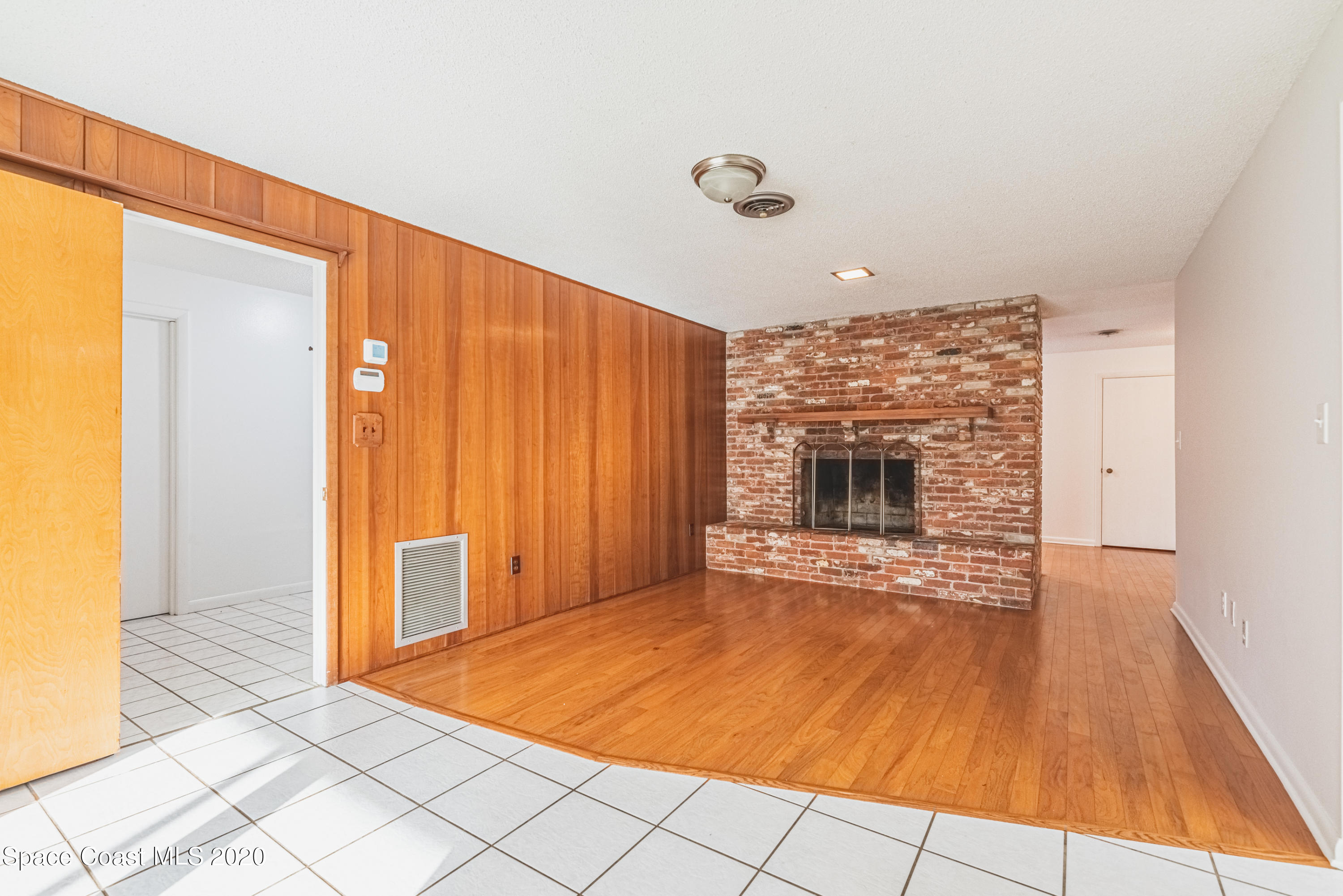 1945 Trimble Road Melbourne, FL 32934 - Photo 27 of 83 a view of an empty room with a fireplace and a window