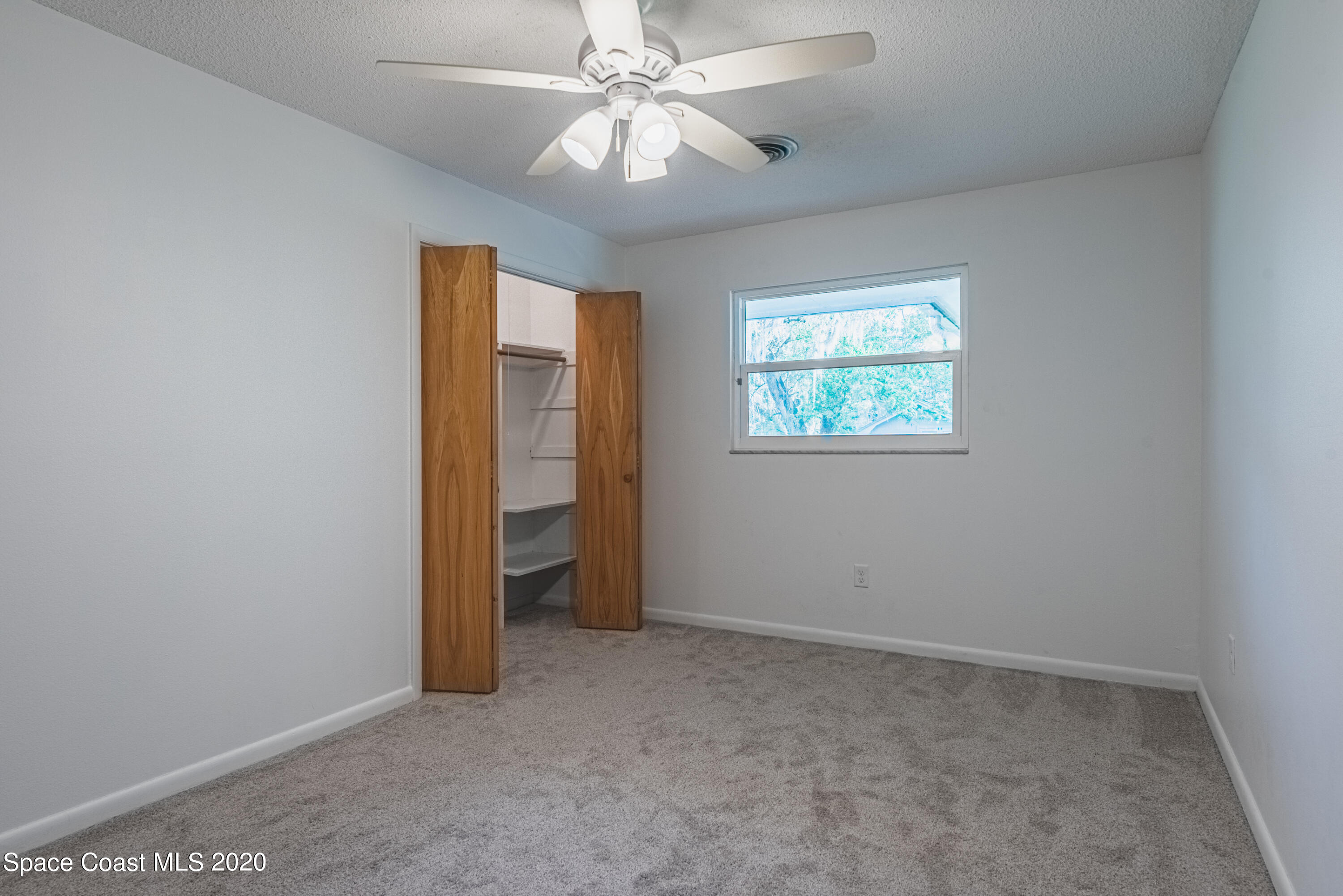 1945 Trimble Road Melbourne, FL 32934 - Photo 30 of 83 an empty room with windows and fan