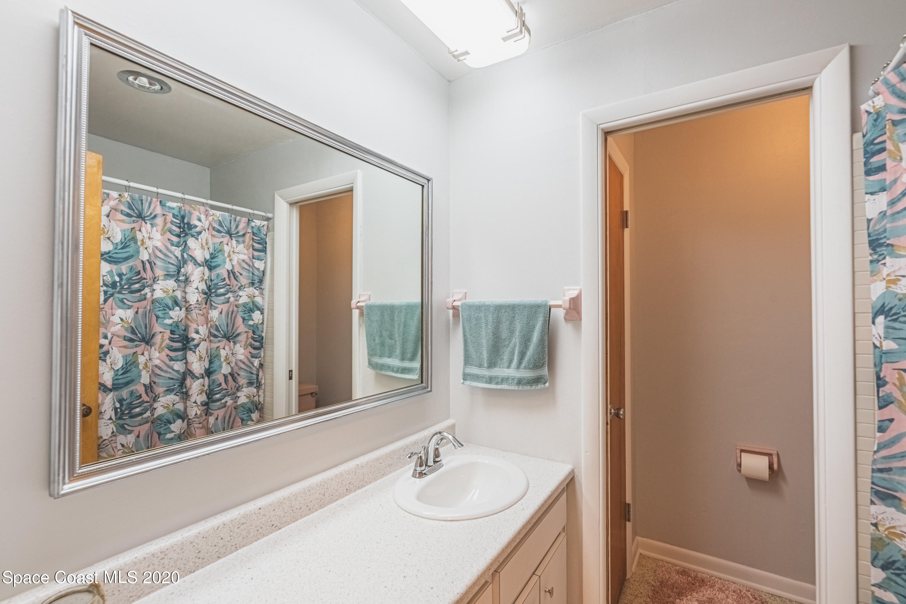 1945 Trimble Road Melbourne, FL 32934 - Photo 32 of 83 a bathroom with a granite countertop sink a mirror and a shower