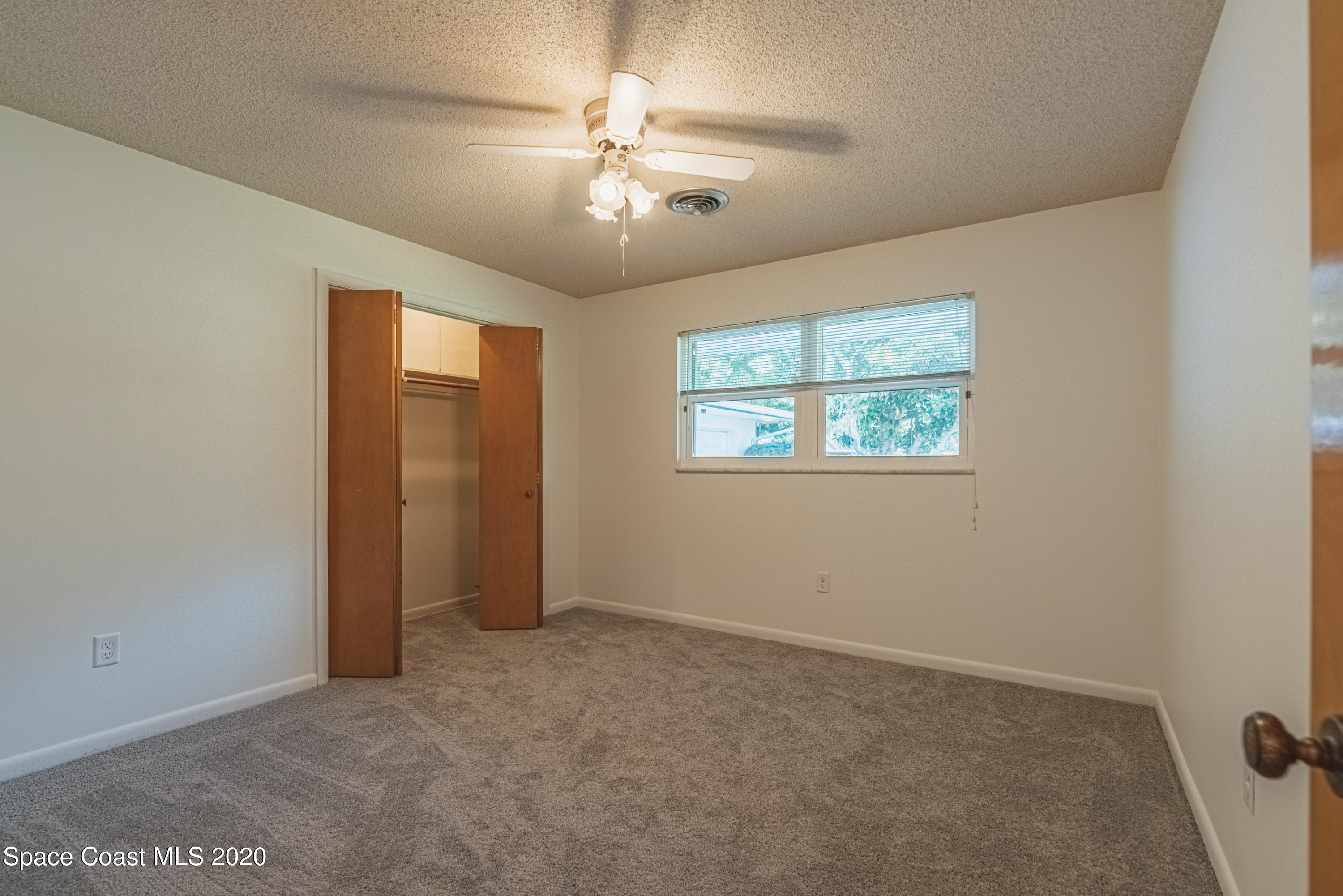 1945 Trimble Road Melbourne, FL 32934 - Photo 34 of 83 en empty room with windows and fan