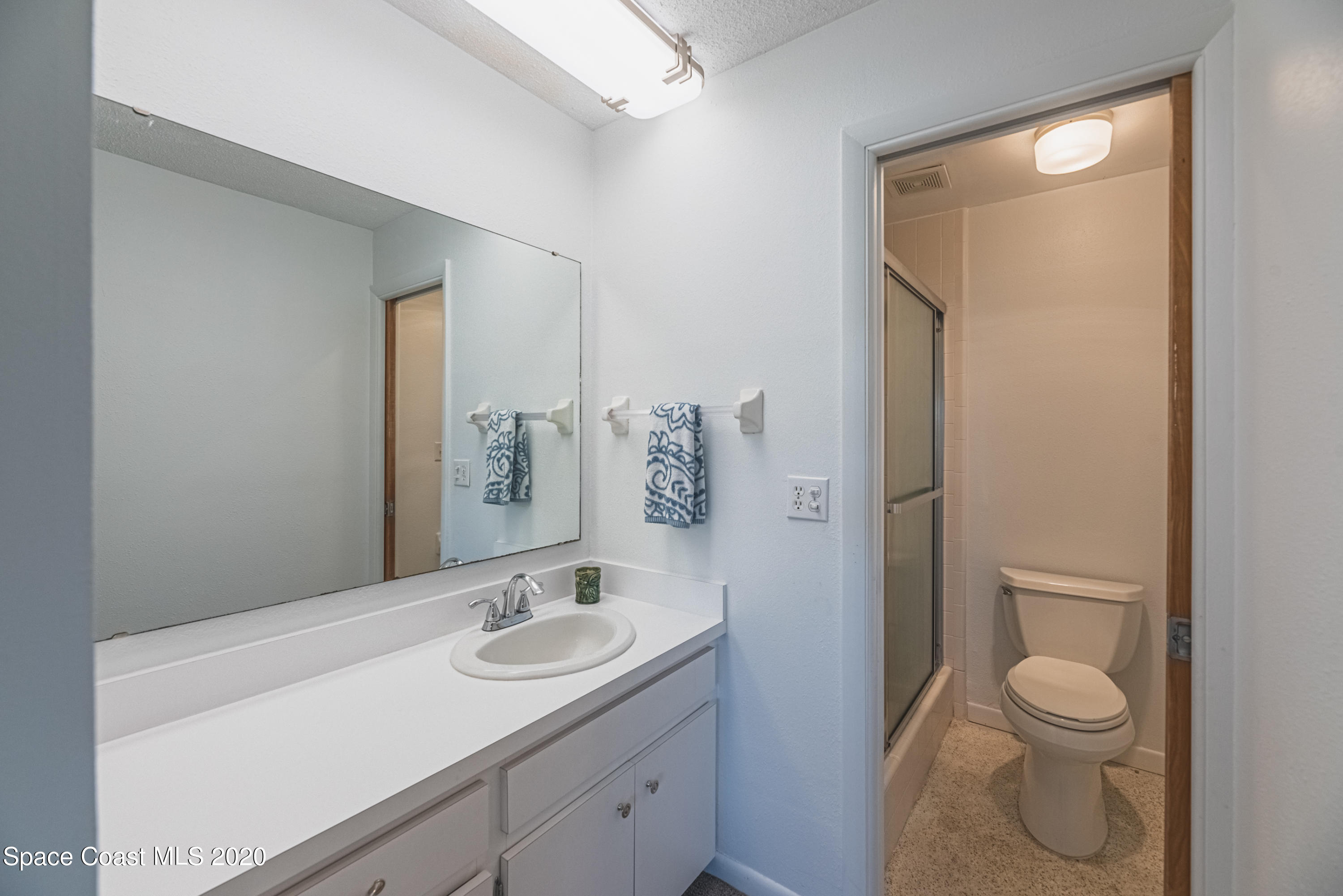1945 Trimble Road Melbourne, FL 32934 - Photo 40 of 83 a bathroom with a granite countertop sink toilet and shower