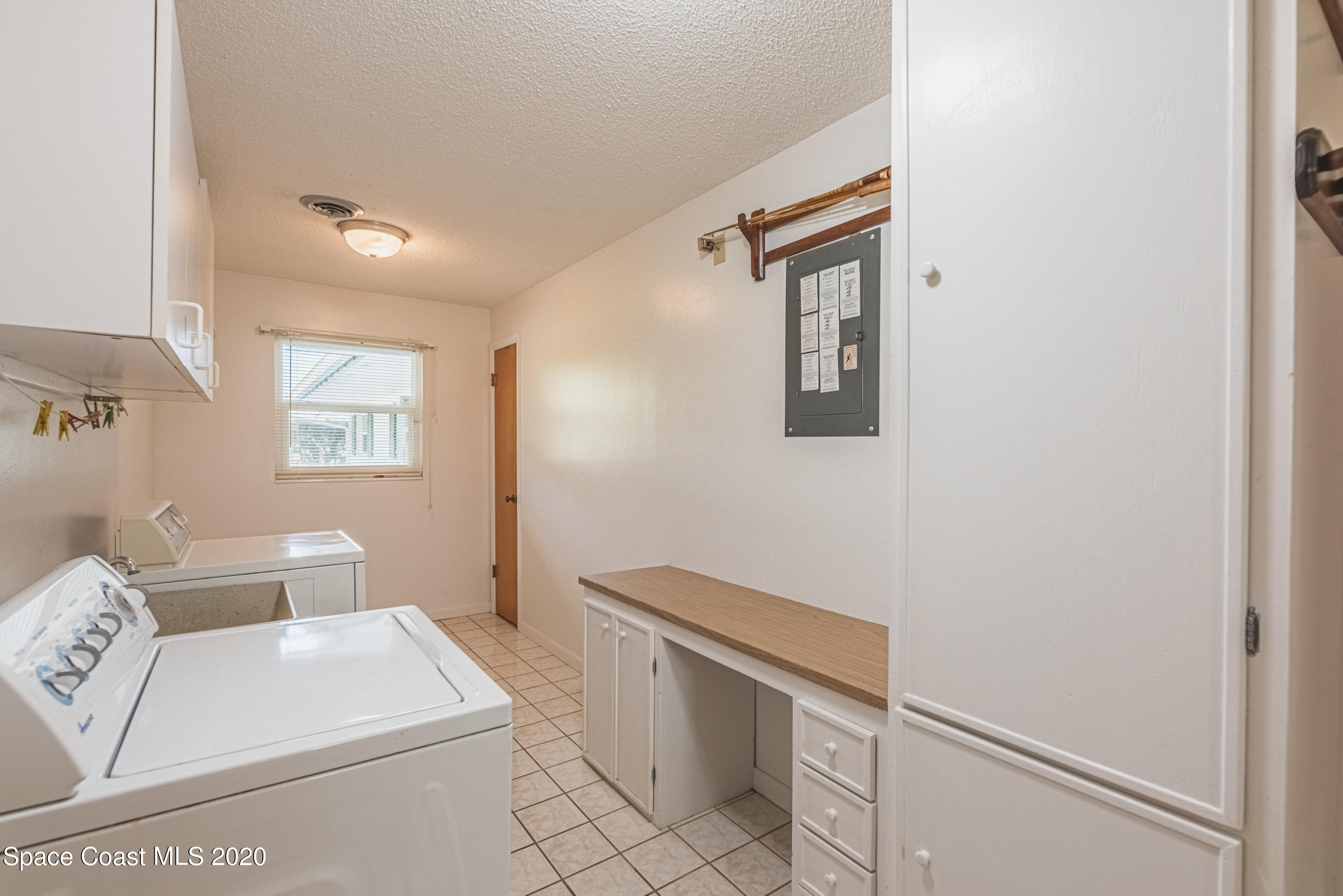 1945 Trimble Road Melbourne, FL 32934 - Photo 43 of 83 a hallway with white cabinets and white appliances