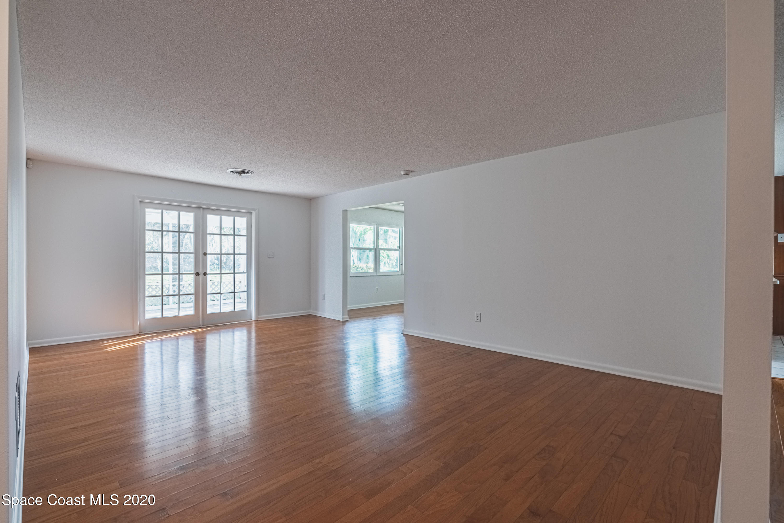 1945 Trimble Road Melbourne, FL 32934 - Photo 58 of 83 a view of an empty room with wooden floor and fan
