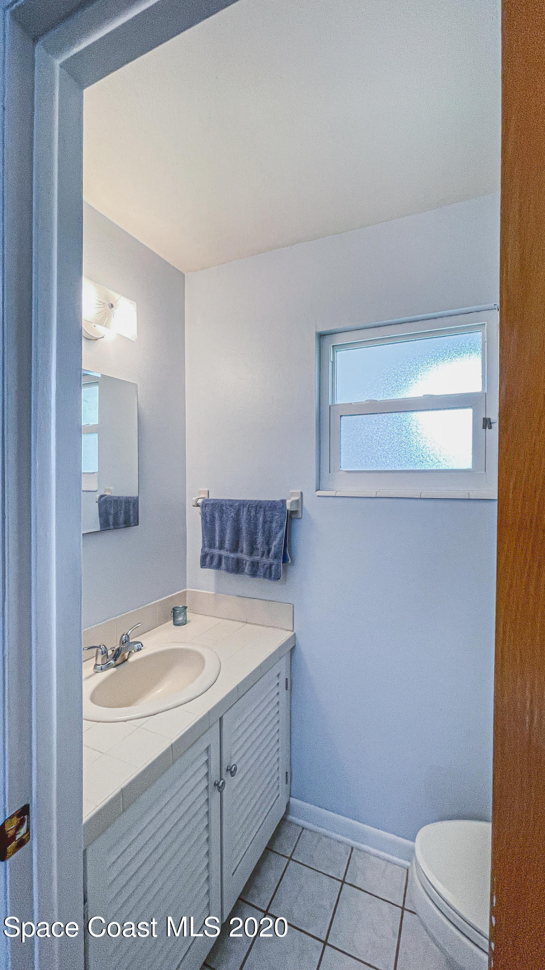 1945 Trimble Road Melbourne, FL 32934 - Photo 71 of 83 a bathroom with a sink a toilet and mirror